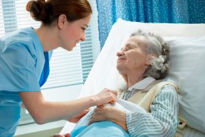 Elderly Woman With Nurse in Hospital Bed