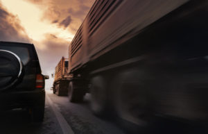 Big truck truck cutting off passenger car on highway. this may call for a lawyer