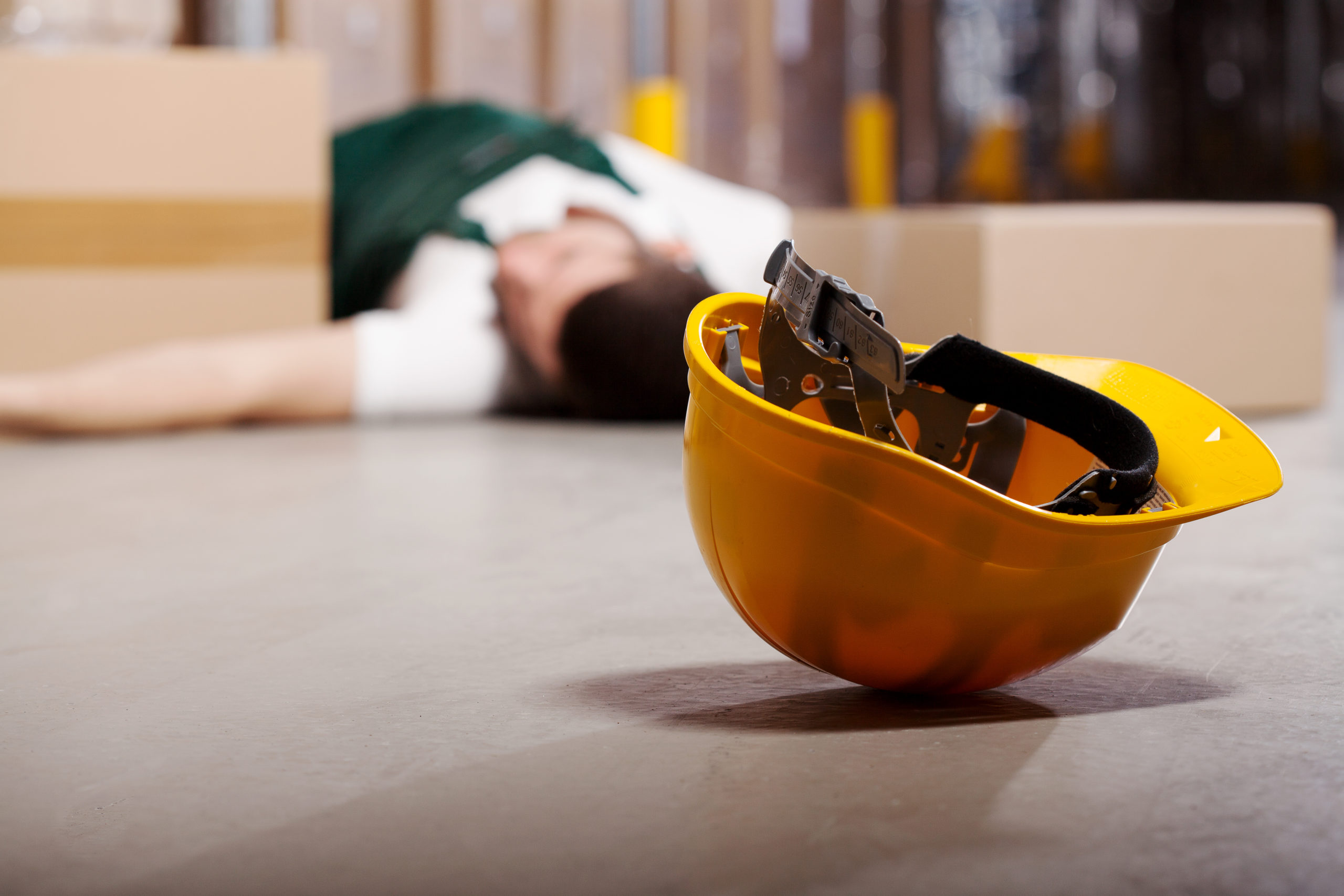 Fallen worker at worksite with safety helmet on floor