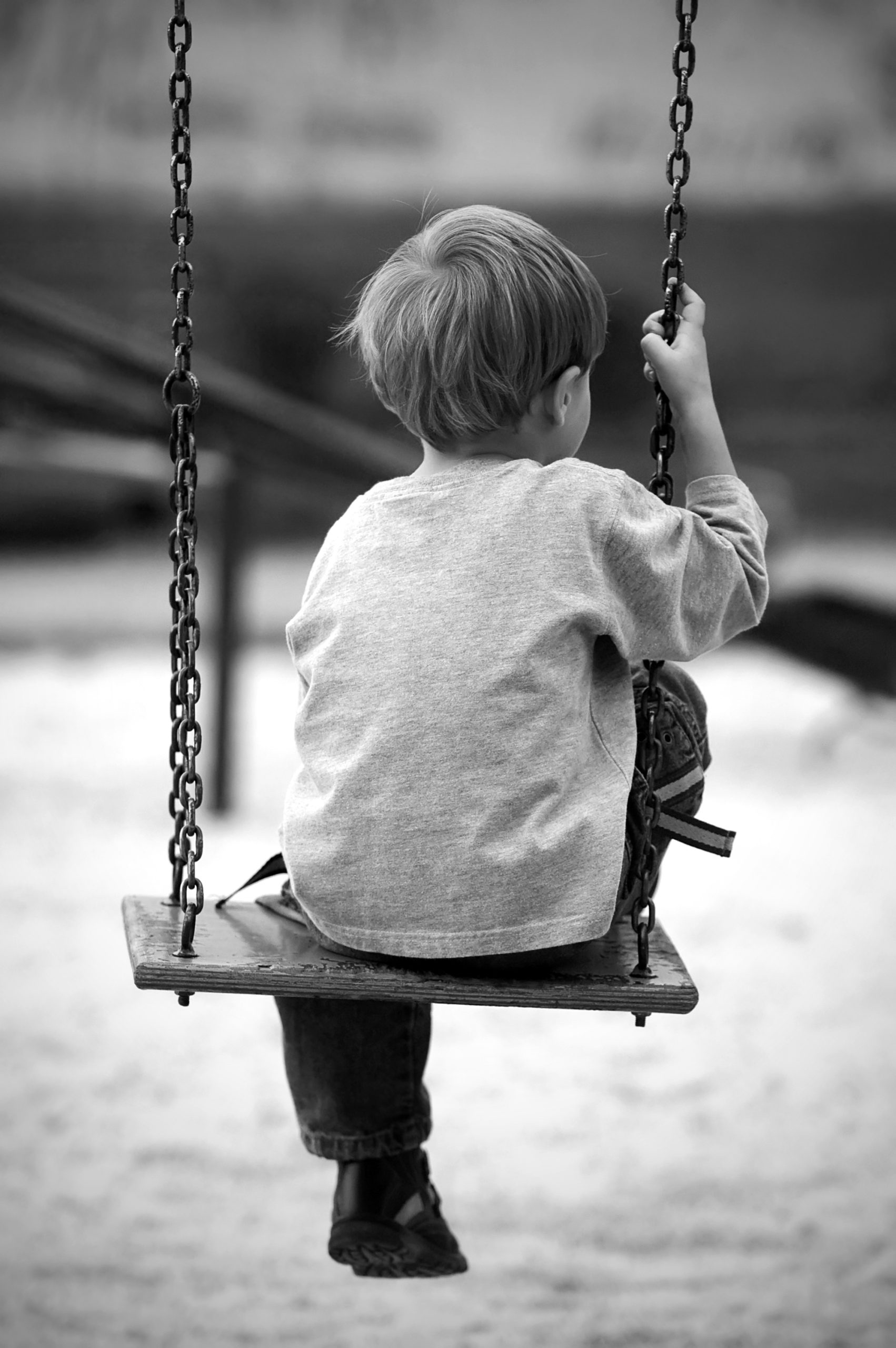 sad boy on playground swing sexual abuse victim