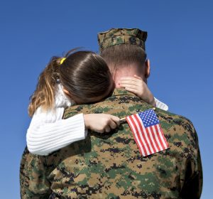 Father holding daughter with flag