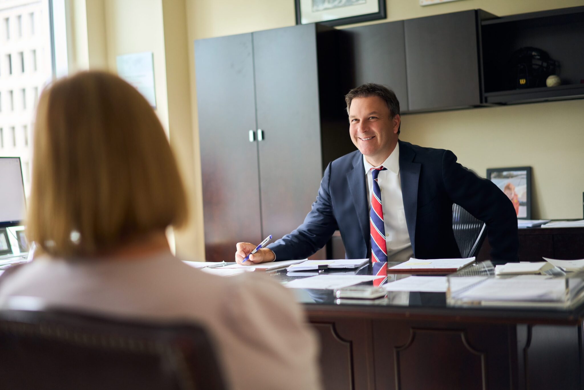 Paul Cornoni seated at desk with client