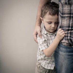 wrongful death, sad young boy holding onto his father