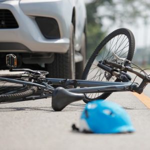 bike struck by car with loose helmet on road