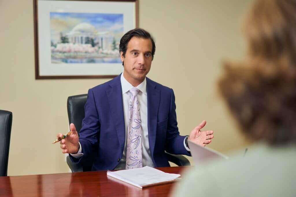 Personal injury lawyer from Regan Zambri Long discussing a case with a potential client during a free consultation at a conference table.