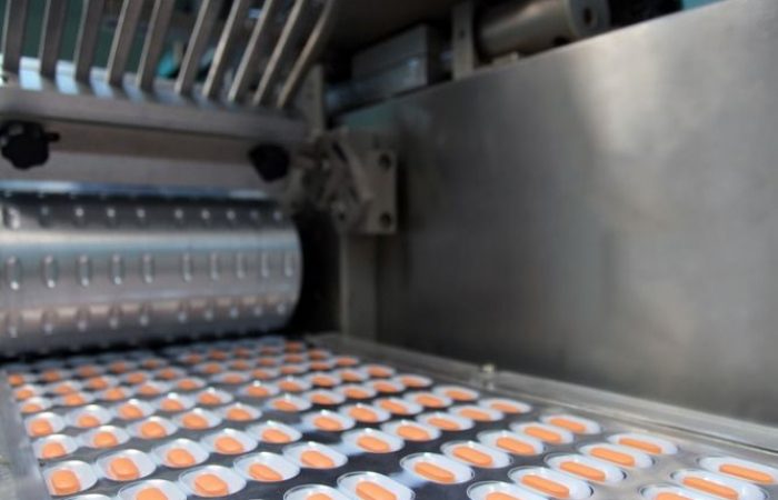 Drugs in tablet form coming out of machine